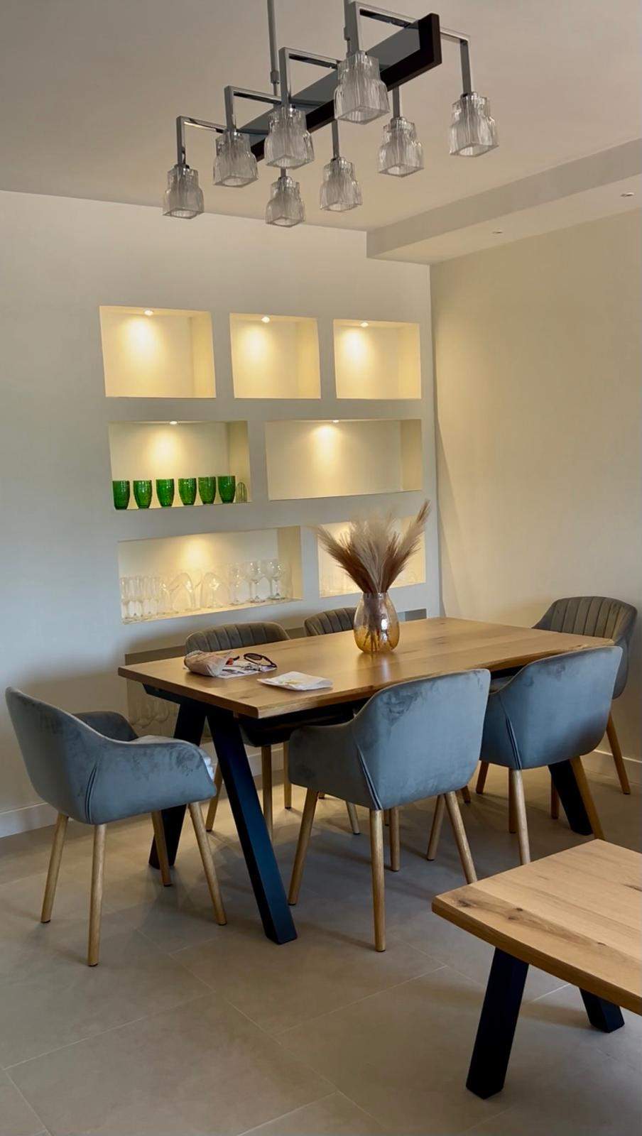 Comedor con mesa de madera y vitrinas iluminadas